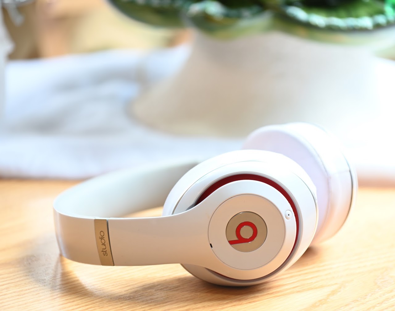 White Beats Studio2 headphones folded on a wooden table