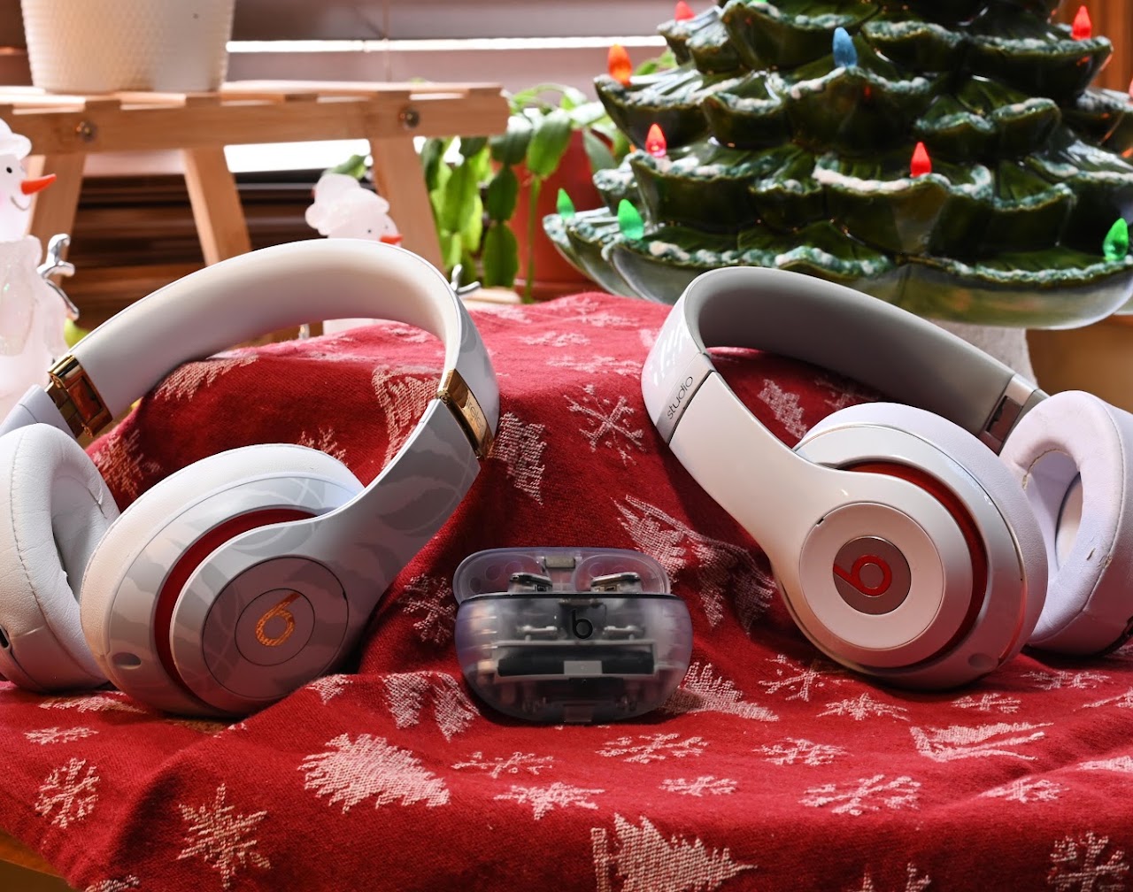 Three Beats headphones arranged together on a red patterned cloth