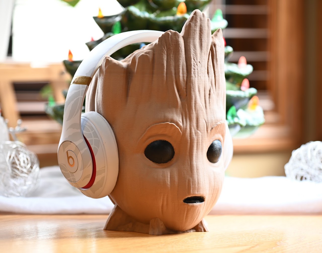 White Beats Studio3 headphones on a carved wooden head display