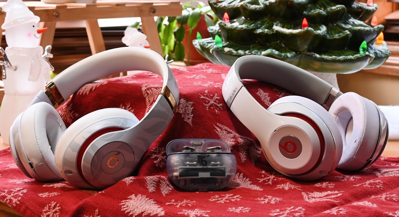 Three Beats headphones arranged together on a red patterned cloth