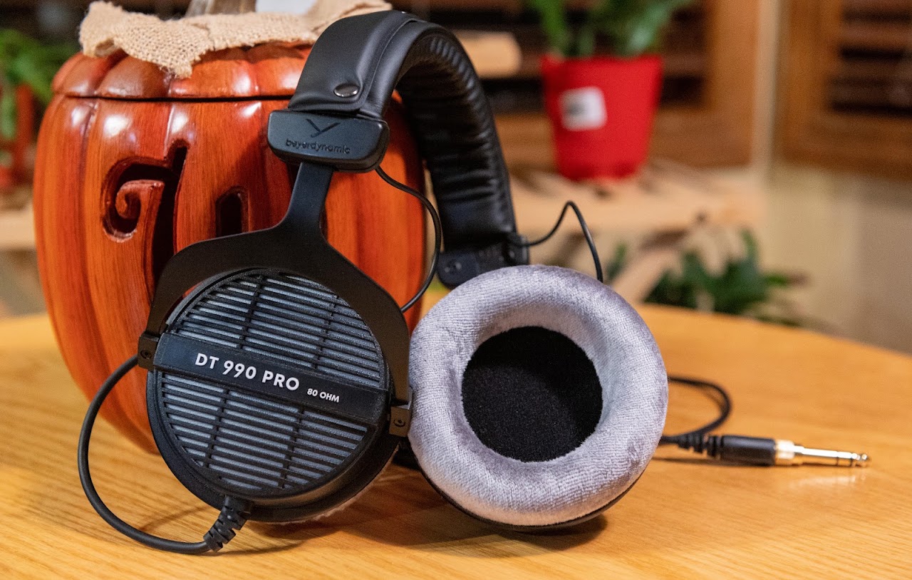 Beyerdynamic DT 990 Pro headphones beside a gray velour ear pad