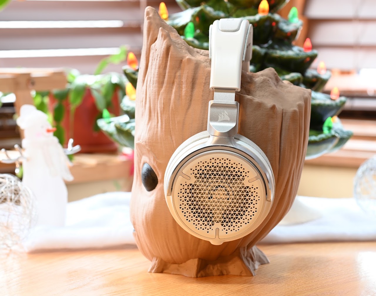 White Corsair Virtuoso Pro headset on a carved wooden head display